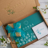 gift wrapped jewellery in brown paper with gold dots & turquoise organza ribbon, Oorla Jewellery branded postcard with hand written note and complimentary jewellery polishing cloth in branded eco friendly pouch with care instructions in a branded eco friendly, letter box sized postal packaging box.